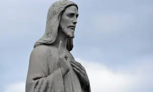 Kamienna figura Jezusa, z uniesionym palcem wskazującym, jakby przemawiając przeciwko schizmie.