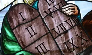 Witraż przedstawia kamienne tablice z rzymskimi cyframi, symbolizujące przykazania boże. Widoczne są cyfry I, II, III, IV, V, VI, VII, VIII, IX, X.
