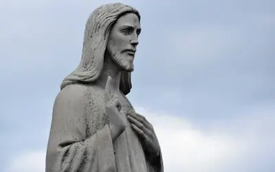 Kamienna figura Jezusa, z uniesionym palcem wskazującym, jakby przemawiając przeciwko schizmie.