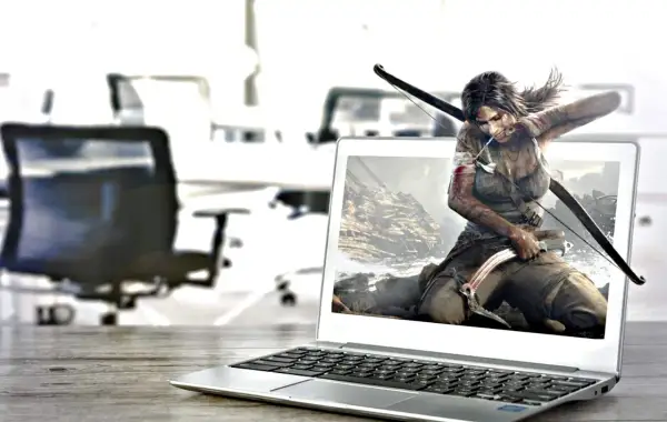 Lara Croft, postać z gry komputerowej, wychodzi z ekranu laptopa, gotowa do akcji z łukiem i czekana.